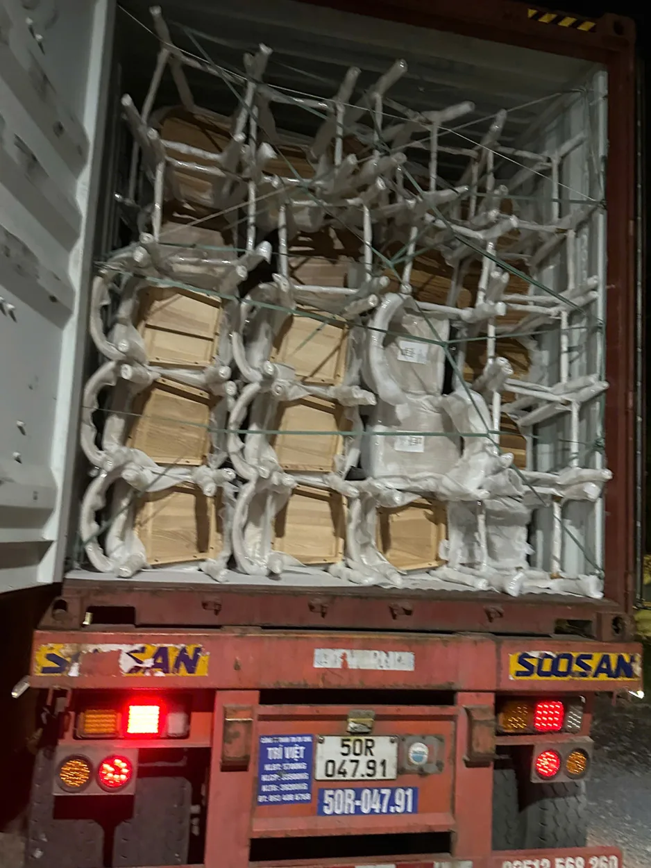 Export container loaded with carefully packaged wooden chairs from Aurora Craft Vietnam, showing secure packaging and reinforcement as part of the Vietnam furniture cost breakdown. Photo taken by phone.
