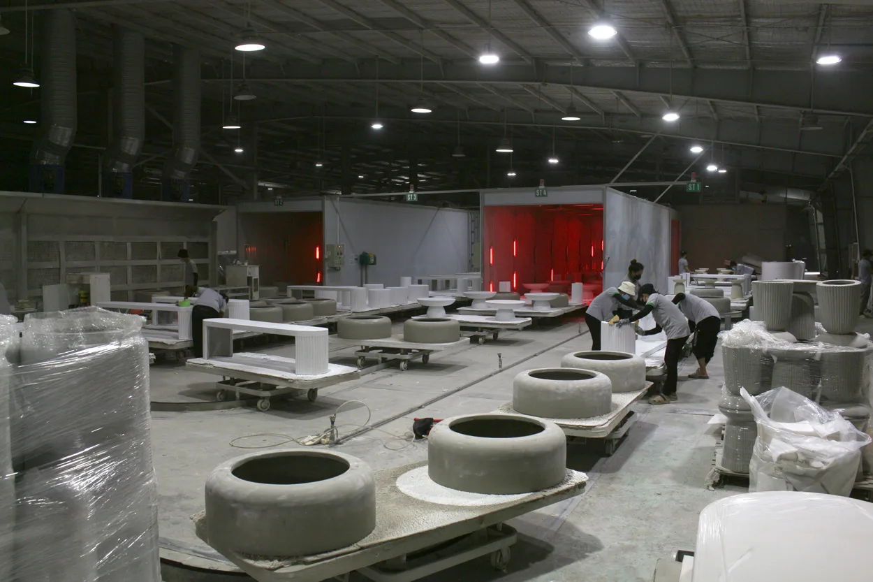 Workers sanding GFRC furniture products at Aurora Craft factory in Vietnam, illustrating indirect costs such as energy, machine maintenance, and labor in the Vietnam furniture cost breakdown.