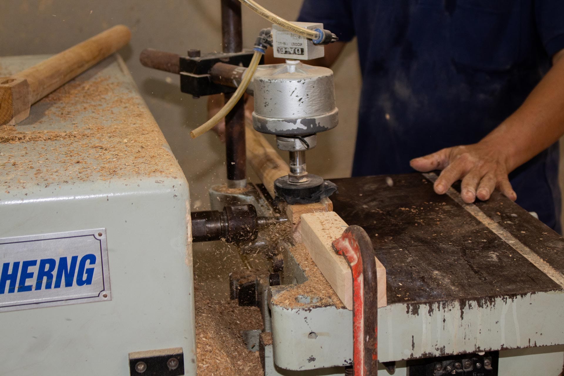 Skilled worker operating woodworking machinery inside a furniture factory Vietnam production facility