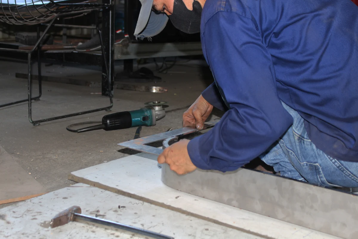 Vietnamese worker metalworking a furniture frame at Aurora Craft’s factory, showcasing the skilled craftsmanship behind Vietnam’s inexpensive outdoor table and chairs.