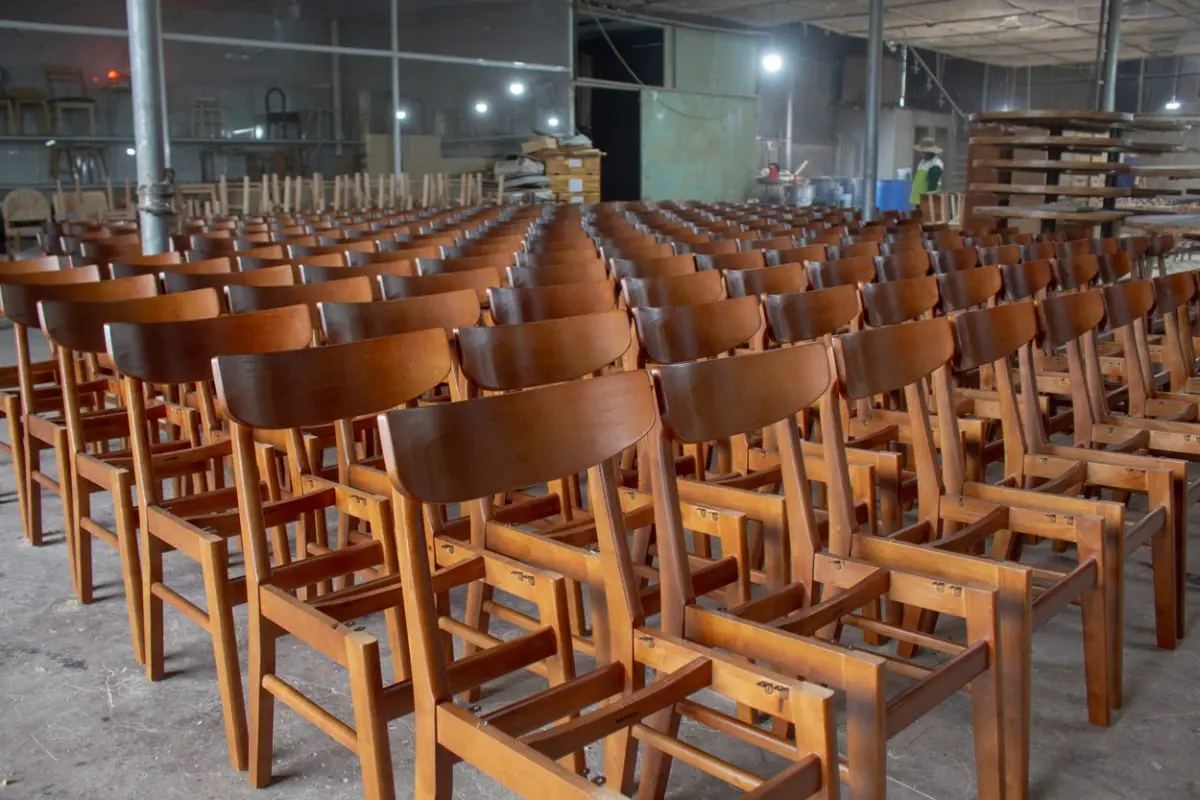 Mass production of wooden chairs at Aurora Craft, a white label furniture manufacturer in Vietnam helping businesses reduce costs and increase efficiency