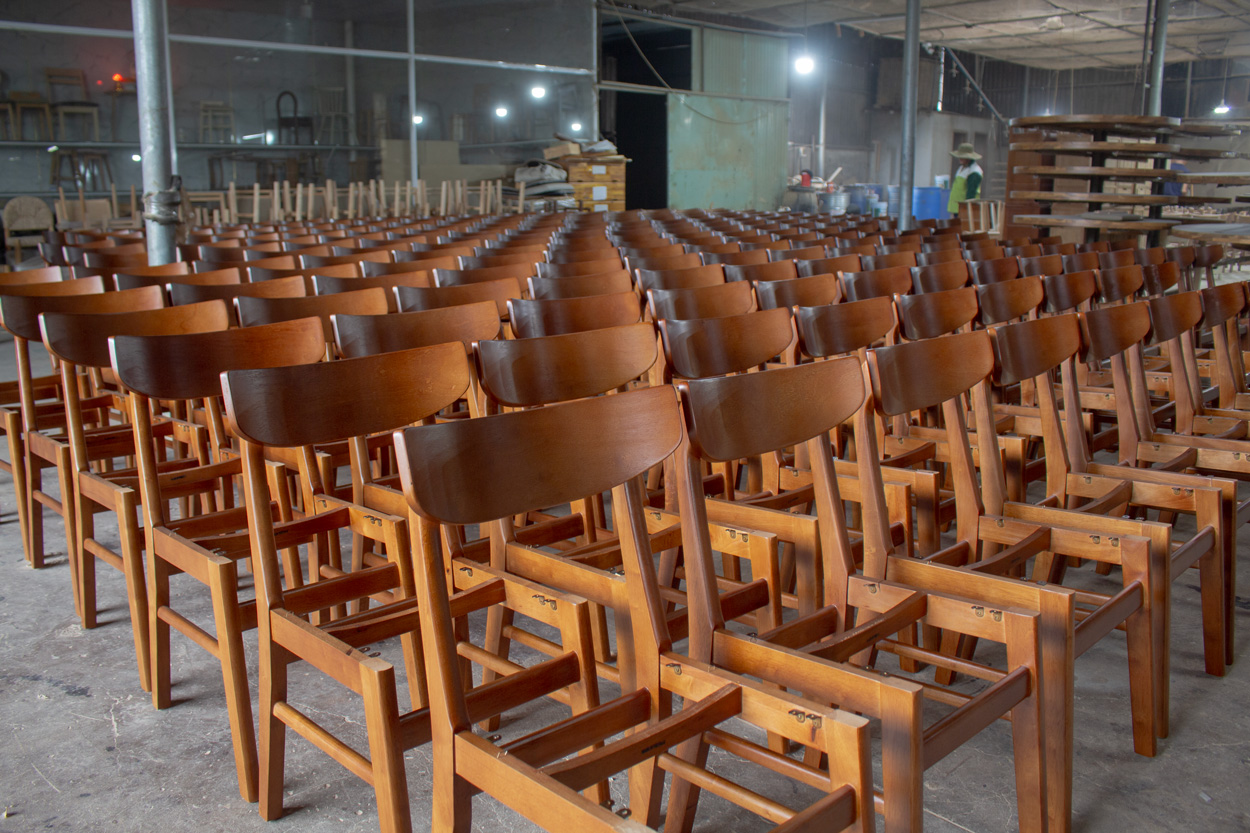 Mass production of wooden chairs at Aurora Craft, a white label furniture manufacturer in Vietnam helping businesses reduce costs and increase efficiency
