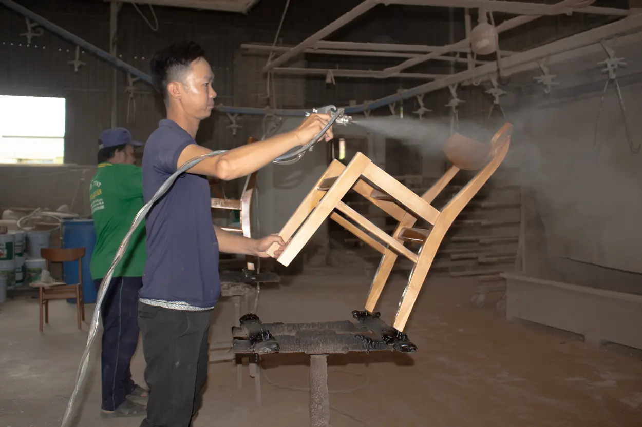 Skilled worker crafting wooden furniture at Aurora Craft’s factory, producing high-quality furniture for retailers.