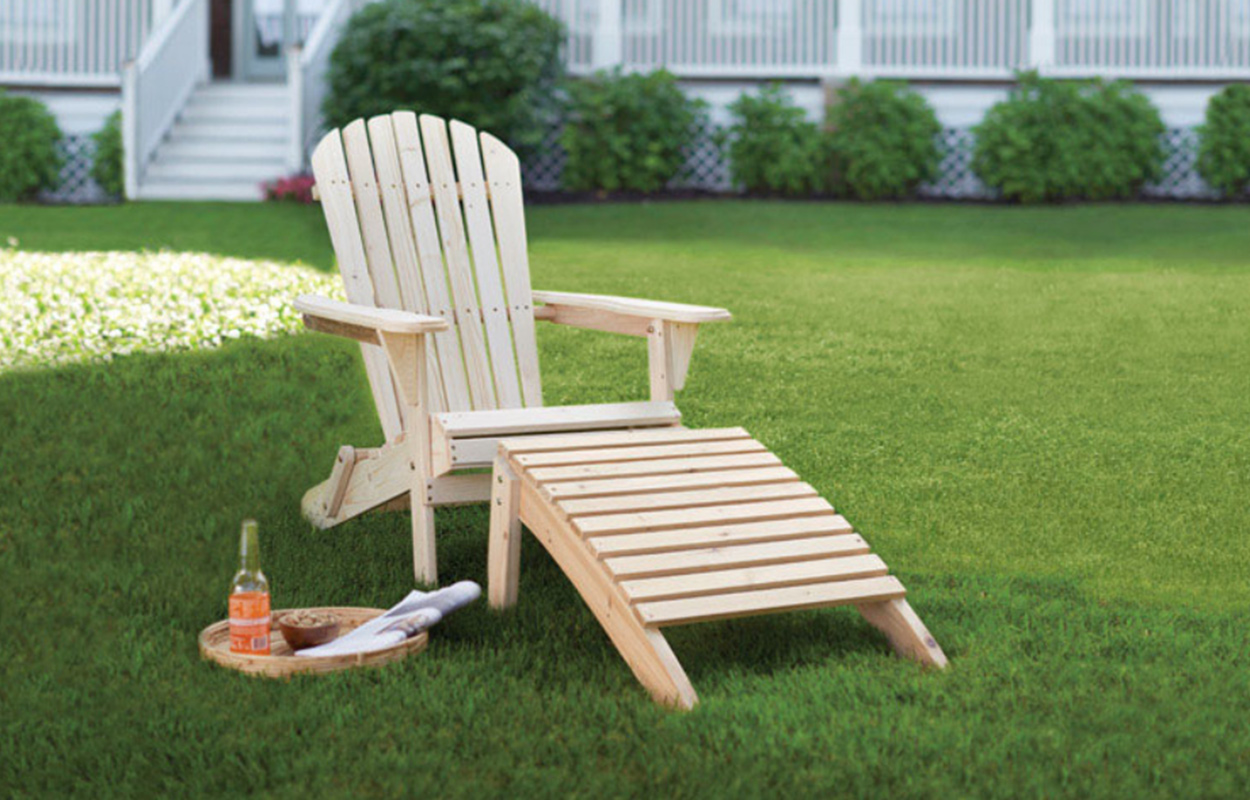 Cedar wood Adirondack chair with matching ottoman placed on a lawn, showing lightweight and insect-resistant wood for outdoor furniture.