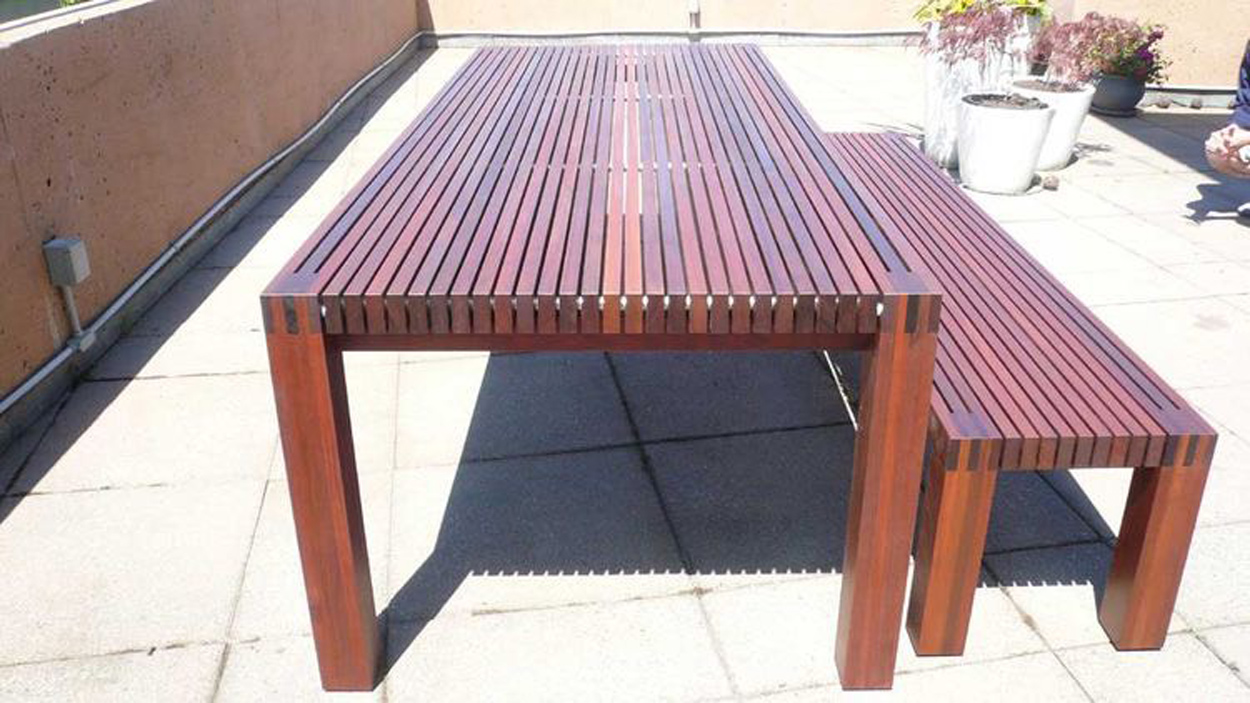 Ipe wood outdoor table and bench set on a patio, showcasing premium and highly durable wood for outdoor furniture.