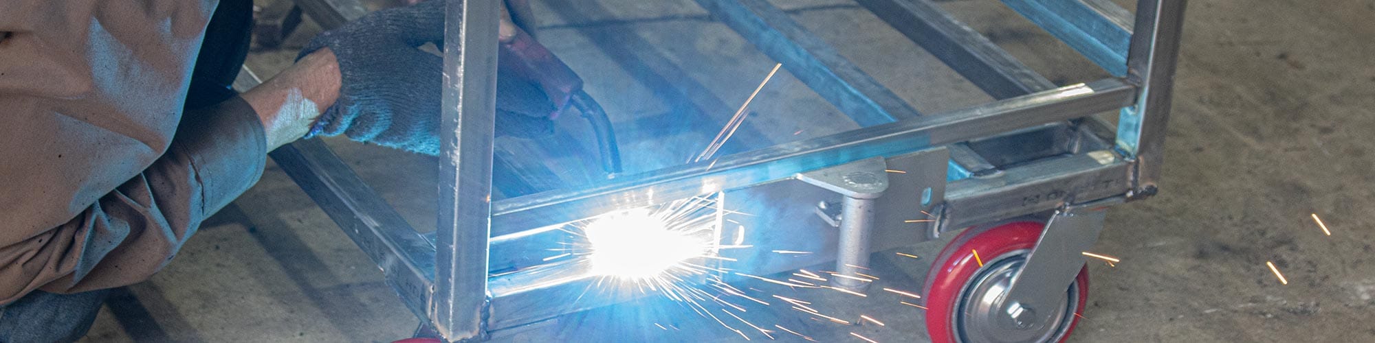 Skilled worker performing welding in metal furniture production demonstrating experienced workforce and manual fabrication expertise